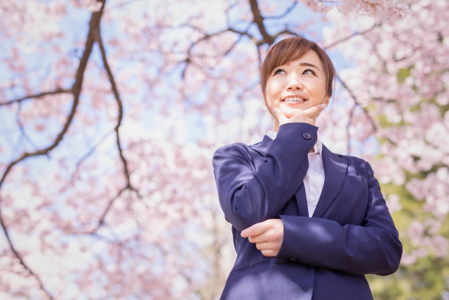 桜の木の前に立つ女性